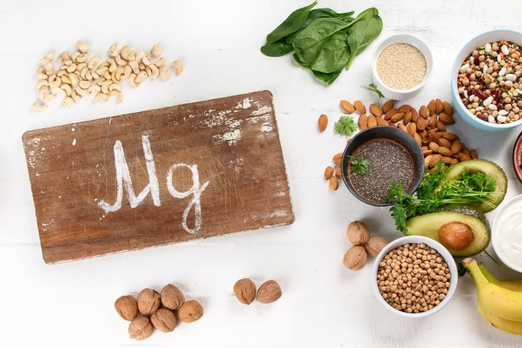 green leafy vegetables, nuts, almonds. yoghurt and beans representing MG supplements. 