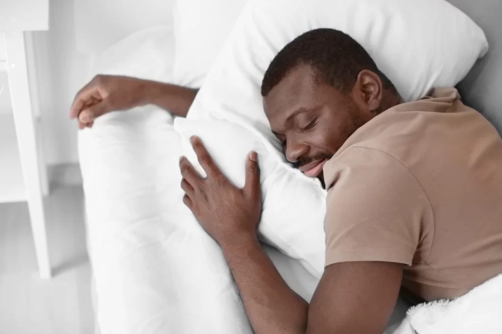 The young black man sleeping on the soft bed.